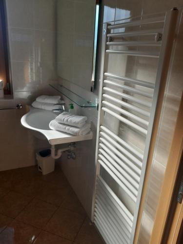 La salle de bains est pourvue d'un lavabo, d'un miroir et de serviettes. dans l'établissement Landgasthof Sonnegghof, à Castelvecchio
