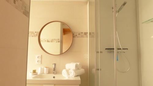 a bathroom with a shower and a sink with a mirror at Douillette maison de ville à Carnac in Carnac