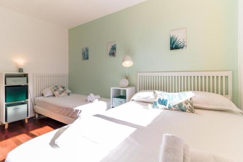 1 dormitorio con 2 camas y TV en SELECT' - Appartement avec vue mer, à quelques metres du centre-ville avec parking - DOLCE VITA, en Le Lavandou