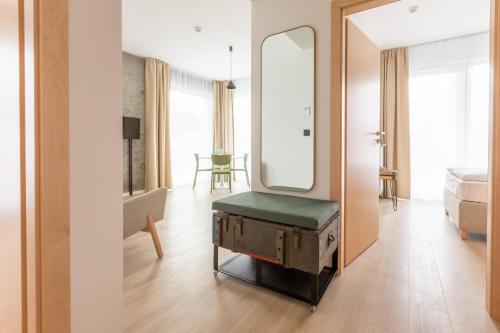 een slaapkamer met een spiegel, een bed en een stoel bij ARCHE Fabryka Samolotów w Mielnie in Mielno