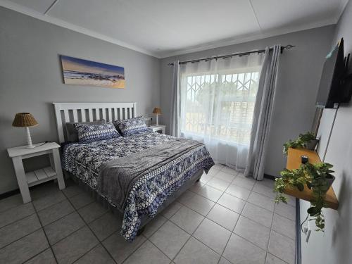 a bedroom with a bed and a window at The Dutch Corner house in Langebaan