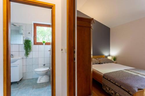 - une chambre avec un lit et une salle de bains avec des toilettes dans l'établissement Elegant Villa Versovica with pool near Pula, à Peruški