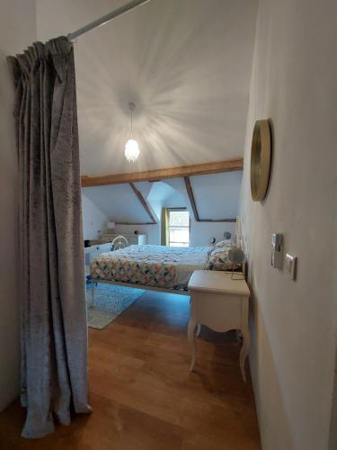 1 dormitorio con 1 cama en el ático en Gite du Grand Chene, en Saint-Léger-Magnazeix