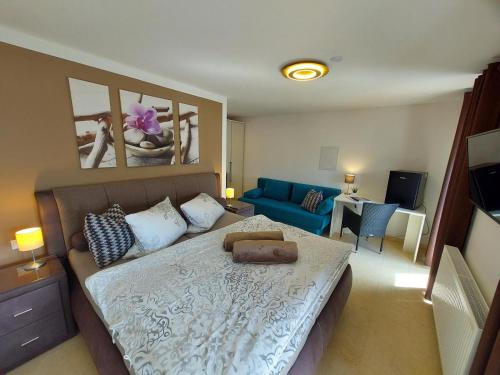 sypialnia z łóżkiem i niebieską kanapą w obiekcie Ferienwohnung und Zimmer zum Donaublick w mieście Kelheim
