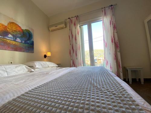 Un dormitorio con una cama grande y una ventana en Zoe Pension, en Ermioni