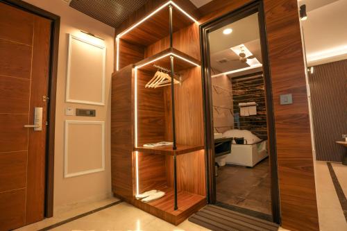 a walk in closet with wooden walls and a mirror at Hotel RJ - Managed by AHG in Greater Noida