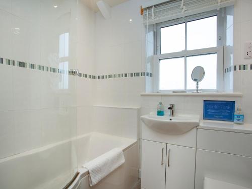 a white bathroom with a tub and a sink at Barn Owl - Uk44607 in Carnbrea