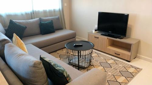 a living room with a couch and a flat screen tv at Beautiful apartment next to airport Mohamed V in Derroua