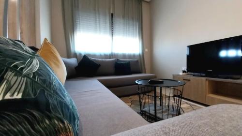 a living room with a couch and a flat screen tv at Beautiful apartment next to airport Mohamed V in Derroua