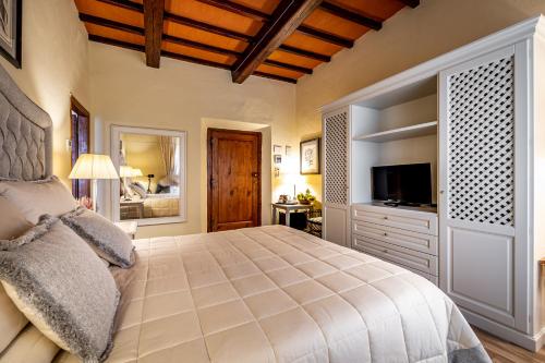 a bedroom with a large bed and a television at Villa S.Andrea in San Casciano in Val di Pesa