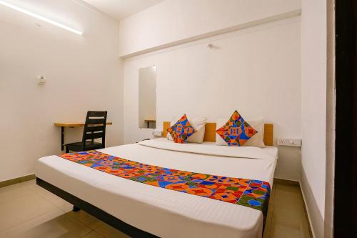 Un dormitorio con 2 camas y una silla. en FabHotel Saubhagya Elite, en Nashik