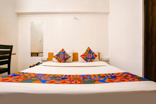 a bedroom with a bed with a colorful blanket on it at FabHotel Saubhagya Elite in Nashik