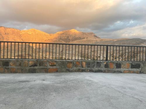 a metal fence with mountains in the background at Jabal Shams, the summit house in Misfāh