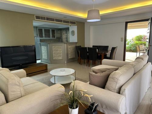 een woonkamer met banken en een flatscreen-tv bij Rentrific in Caïro