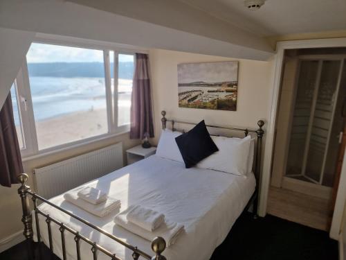a bedroom with a bed with a view of the beach at The Mariners House in Scarborough