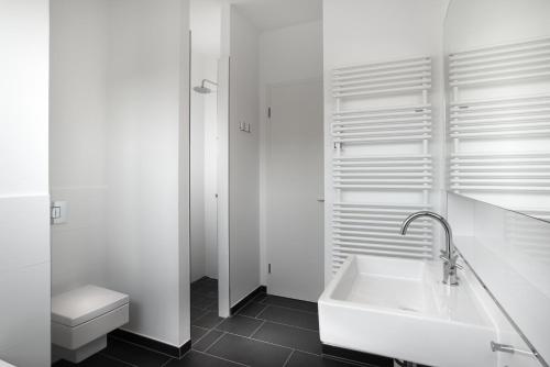 uma casa de banho branca com um lavatório e um WC em Ostsee - Reetdachhaus Nr 38 "RIKE" im Strand Resort em Heiligenhafen