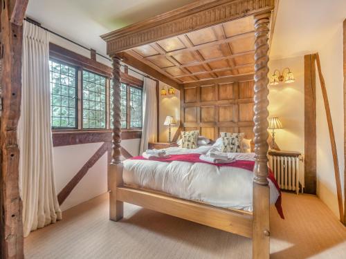1 dormitorio con cama con dosel y ventana en Ridge Hill Manor en Turners Hill