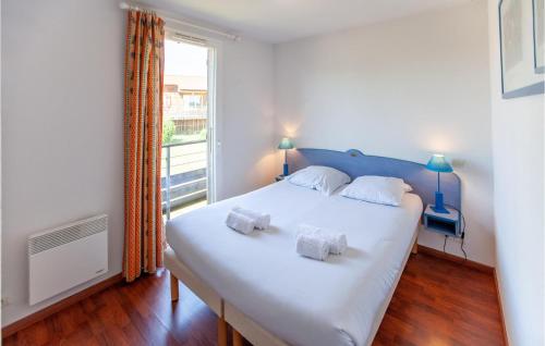 2 Bedroom Lovely Apartment In Cassen في Cassen: غرفة نوم بسرير ابيض كبير ونافذة