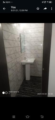y baño con lavabo blanco y espejo. en SPOT ON Shree Jee Ghust House en Bandikui