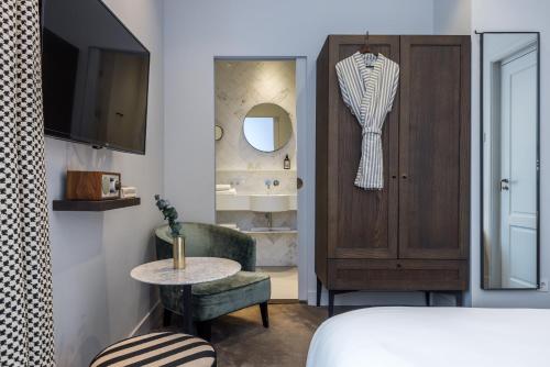 um quarto com uma cama, uma mesa e um espelho em Maison ELLE Amsterdam em Amsterdã