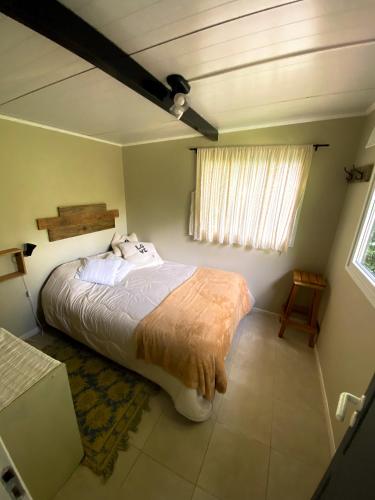 ein Schlafzimmer mit einem großen Bett in einem Zimmer mit einem Fenster in der Unterkunft Amapola Tiny House in San Carlos de Bariloche