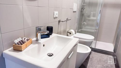 un bagno bianco con lavandino e WC di HT - Elegante mini in Prato della Valle a Padova