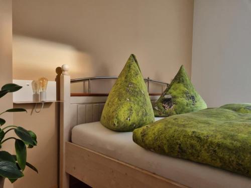 a bed with green pillows on top of it at Ferienwohnung Familie Buchner in Großheubach