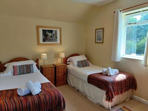 a bedroom with two beds and a window at Finest Retreats - Little Dunley - Lake View in Bovey Tracey