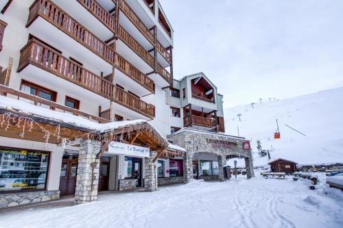 un gran edificio con nieve en el suelo delante de él en Vacancéole - Le Borsat IV, en Tignes