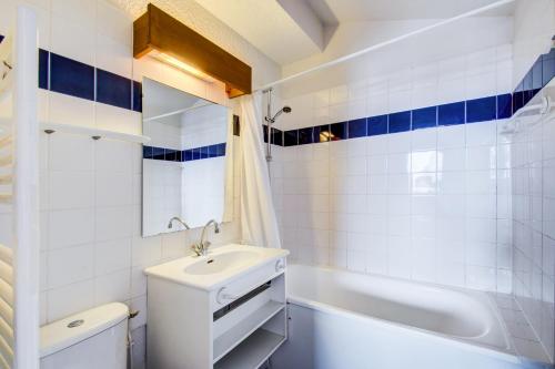a bathroom with a sink and a tub and a toilet at Vacancéole - Le Borsat IV in Tignes