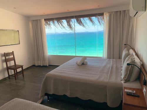 a bedroom with a bed with a view of the ocean at Orlanova Hotel in Arraial do Cabo