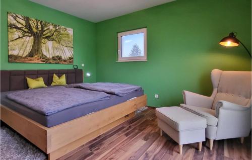3 Bedroom Cozy Home In Langlau في لانغلاو: غرفة نوم خضراء بسرير وكرسي