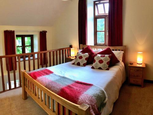 a bedroom with a large bed with red curtains at Finest Retreats - Little Dunley - Fig Cottage in Bovey Tracey