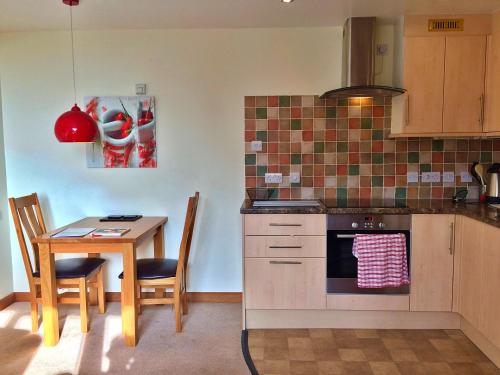 a kitchen with a table and a stove and a table and chairs at Finest Retreats - Little Dunley - Fig Cottage in Bovey Tracey