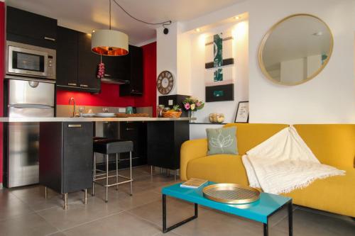 a living room with a yellow couch and a kitchen at Le Bobillot By ApiRent #Central #Terrasse #Wifi #Clim in Cannes
