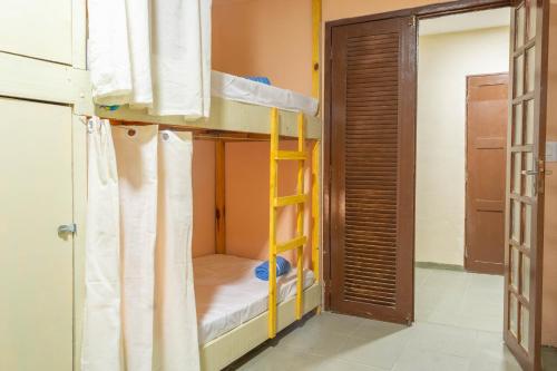 a bunk bed with a ladder in a room at Makeba Hostel in Pipa