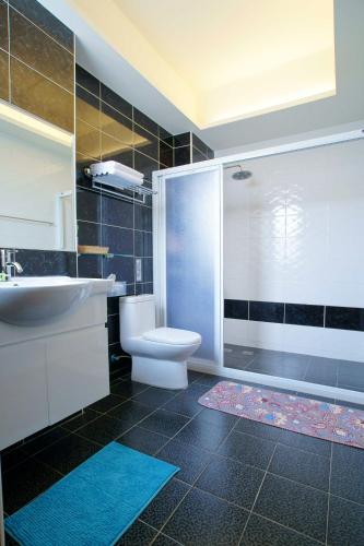 a bathroom with a toilet and a sink and a shower at Knight Inn in Taitung City