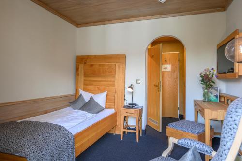 a hotel room with a bed and a desk and a chair at Biohotel Garmischer Hof in Garmisch-Partenkirchen
