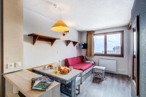 a living room with a red couch and a table at Vacancéole - Le Borsat IV in Tignes