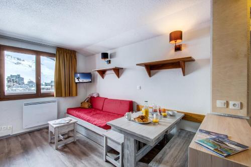 a living room with a red couch and a table at Vacancéole - Le Borsat IV in Tignes