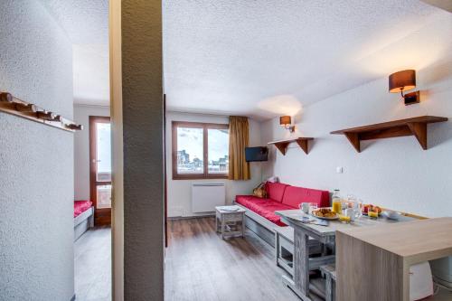 a living room with a red couch and a table at Vacancéole - Le Borsat IV in Tignes