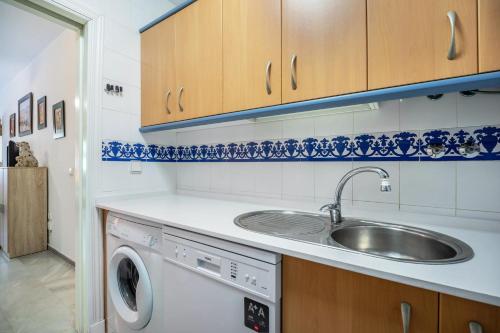 a kitchen with a sink and a washing machine at Casa Amparo Sancti Petri in Novo Sancti Petri