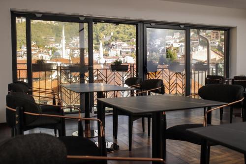 a restaurant with tables and chairs and a balcony at Triumf Hotel in Prizren