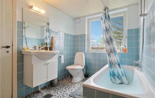 łazienka z wanną, toaletą i umywalką w obiekcie 3 Bedroom Lovely Home In stermarie w mieście Østermarie