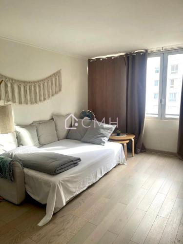 a bedroom with a white bed and a large window at Modern Porte de Versailles Flat - Expo Next Door in Vanves