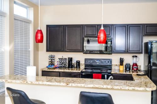 a kitchen with black cabinets and a stove at Luxury 3 Bedrooms with King bed Downtown Indy in Indianapolis