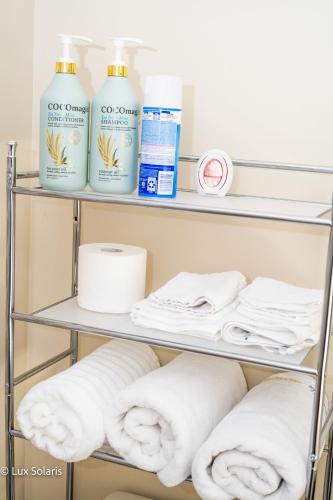a shelf with towels and cleaning products on it at Luxury 3 Bedrooms with King bed Downtown Indy in Indianapolis