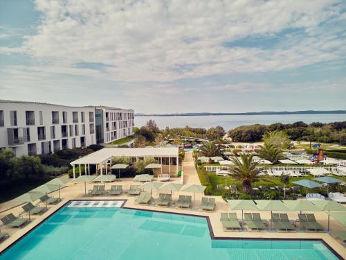 uma vista aérea de um resort com uma piscina e cadeiras em Falkensteiner Family Hotel Diadora em Zadar