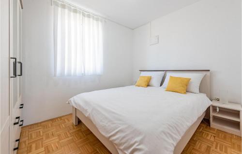 1 dormitorio blanco con 1 cama blanca grande con almohadas amarillas en Vila Sidro, en Košljun