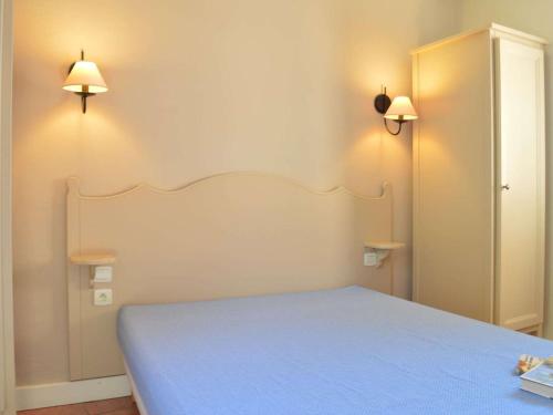 - une chambre avec un lit et deux lumières sur le mur dans l'établissement Appartement 6 couchages avec piscine et parking aux Issambres - FR-1-226-386, aux Issambres